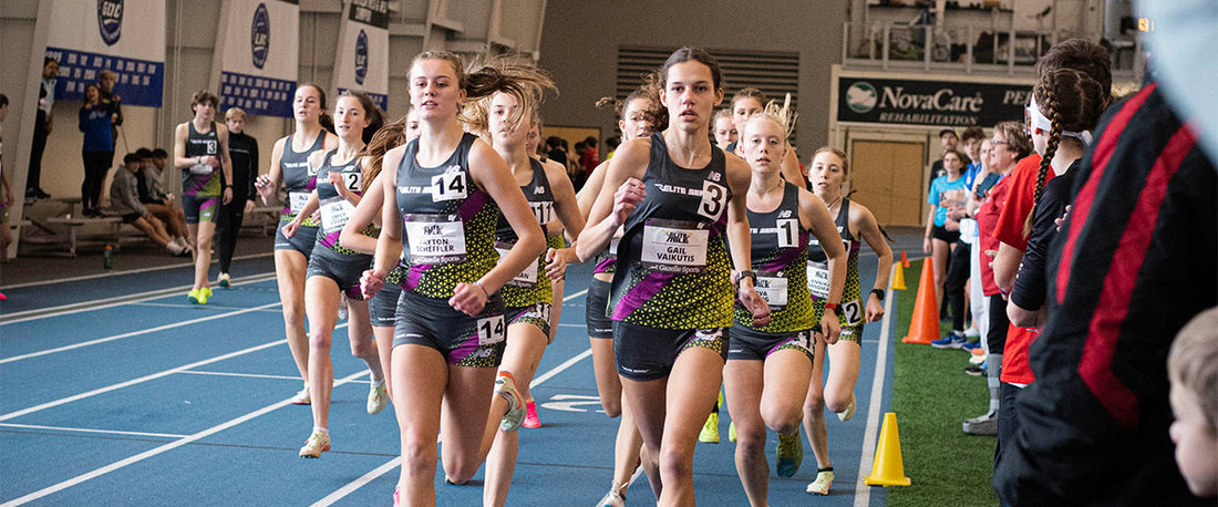 High School girls running on indoor track in track spikes